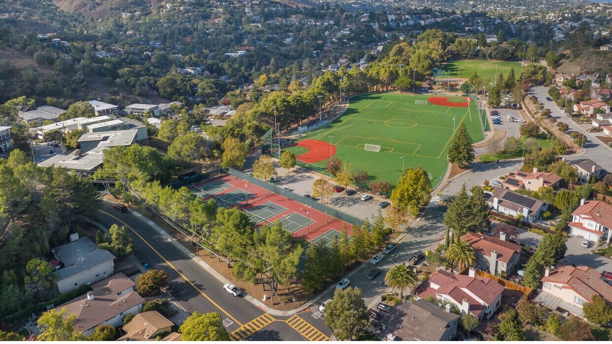 Aerial view of Highlands Park in San Carlos with soccer fields, tennis courts, and surrounding hillside homes.