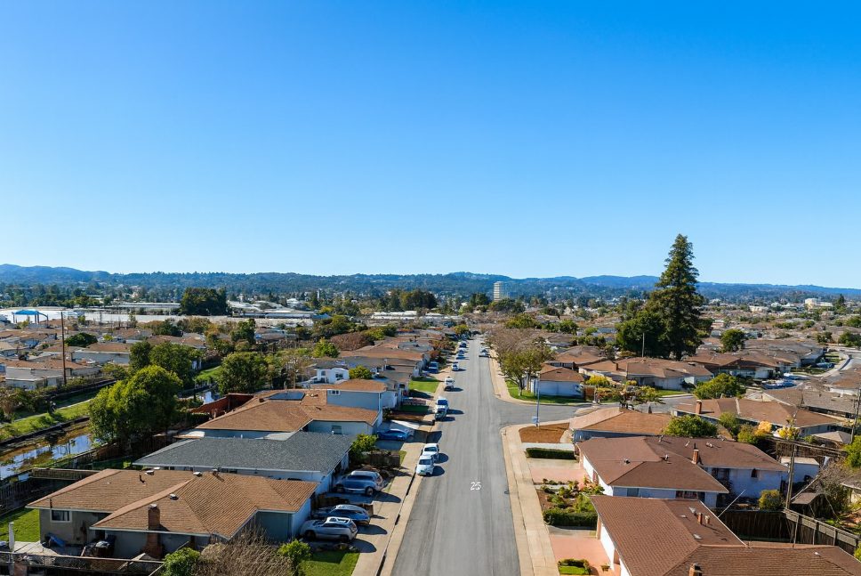 Aerial view of residential street in The Village San Mateo neighborhood showing single-family homes with driveways